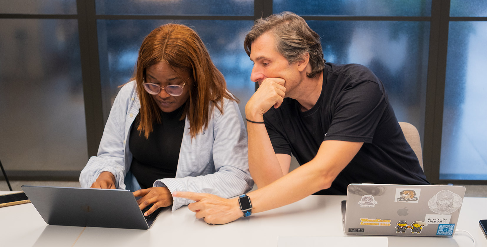 A picture of several Illustrate Digital team members in Bristol discussing a WordPress website project for a client