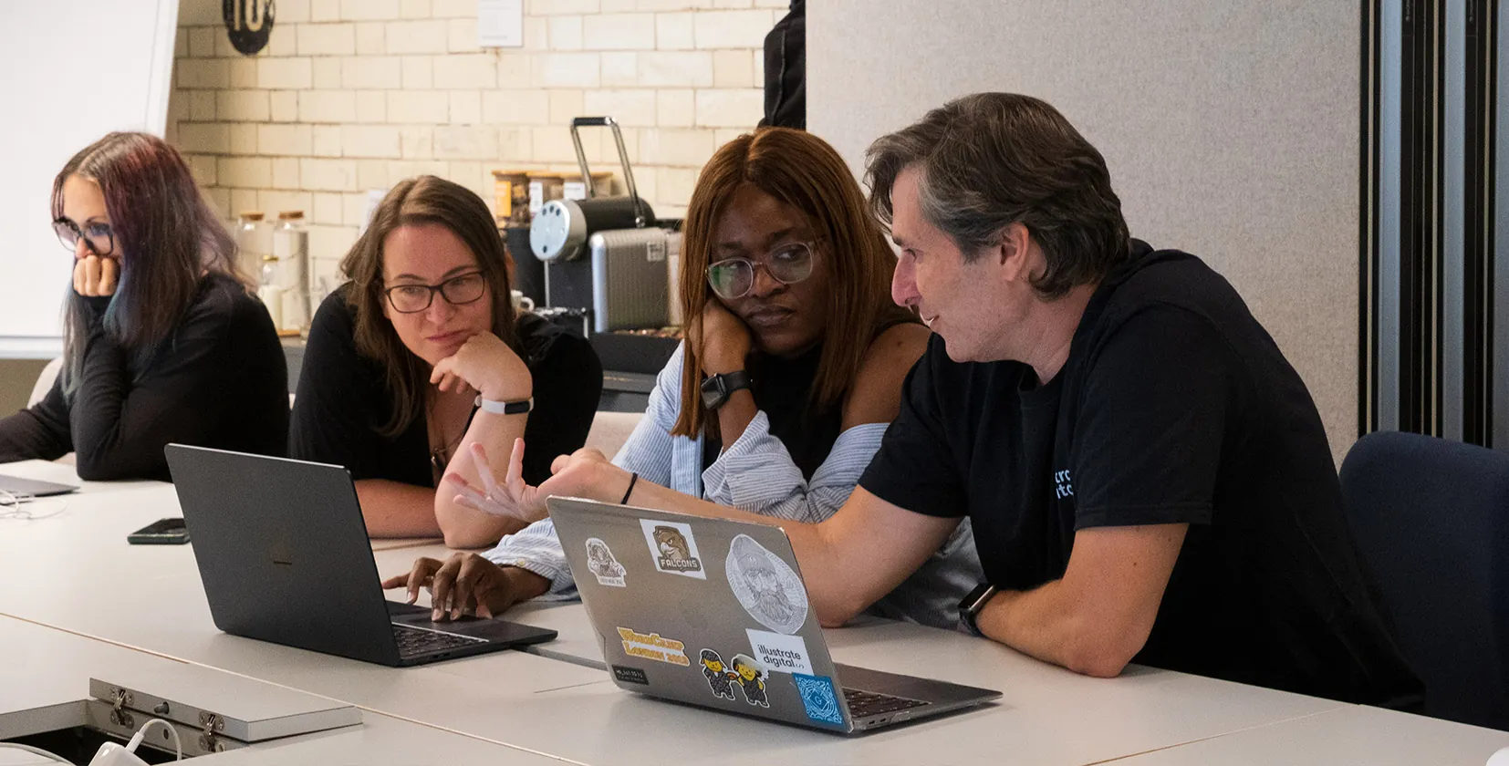 A picture of several Illustrate Digital team members in Bristol discussing a WordPress website project for a client